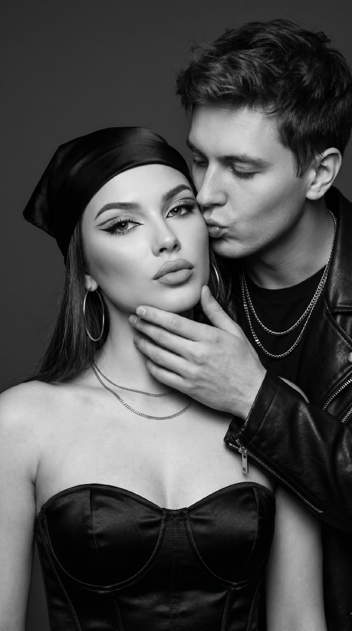ИИ-фотосессия по фото: чёрно-белый fashion-портрет пары крупным планом, мужчина в кожаной куртке целует девушку в атласном корсете.